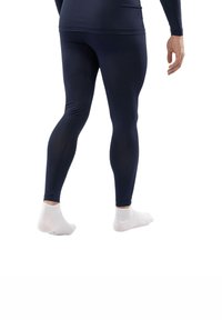 Marineblauwe sportleggings van rekbare stof, slim-fit ontwerp, gladde textuur, gedragen met witte enkelsokken, schuine kijk vanaf achteren.
