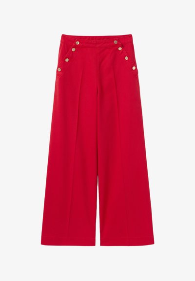 Pantalons larges rouges à taille haute, présentant des accents de boutons dorés à l'avant et des plis pour plus de texture et de détail.