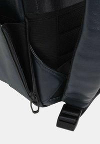 Borsa in pelle blu navy con tasche con zip e a rete, hardware robusto e tracolla regolabile. La superficie liscia ne aumenta la durata.