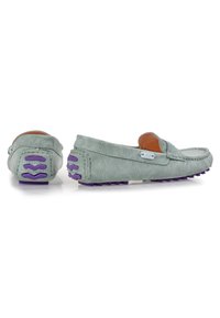 Mocassini verde chiaro in pelle texturizzata, con suola in gomma viola a contrasto e dettagli di cucitura decorativa. Design a profilo basso.