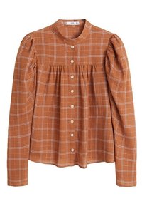 Chemise à manches longues à carreaux marron, avec un col et un devant boutonné, présentant une texture froncée sous la poitrine. Tissu doux avec un léger éclat.