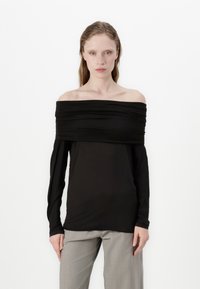 Black off-shoulder long-sleeve top featuring gathered fabric along the neckline, with a smooth, lightweight texture and slim fit.