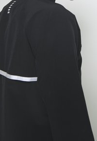 Under Armour Běžecká bunda - black