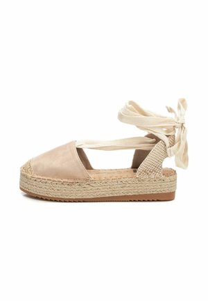 Espadrille beige con parte superior de ante, plataforma de yute trenzado y lazos en el tobillo. Presenta lados recortados y acentos texturizados en el talón.