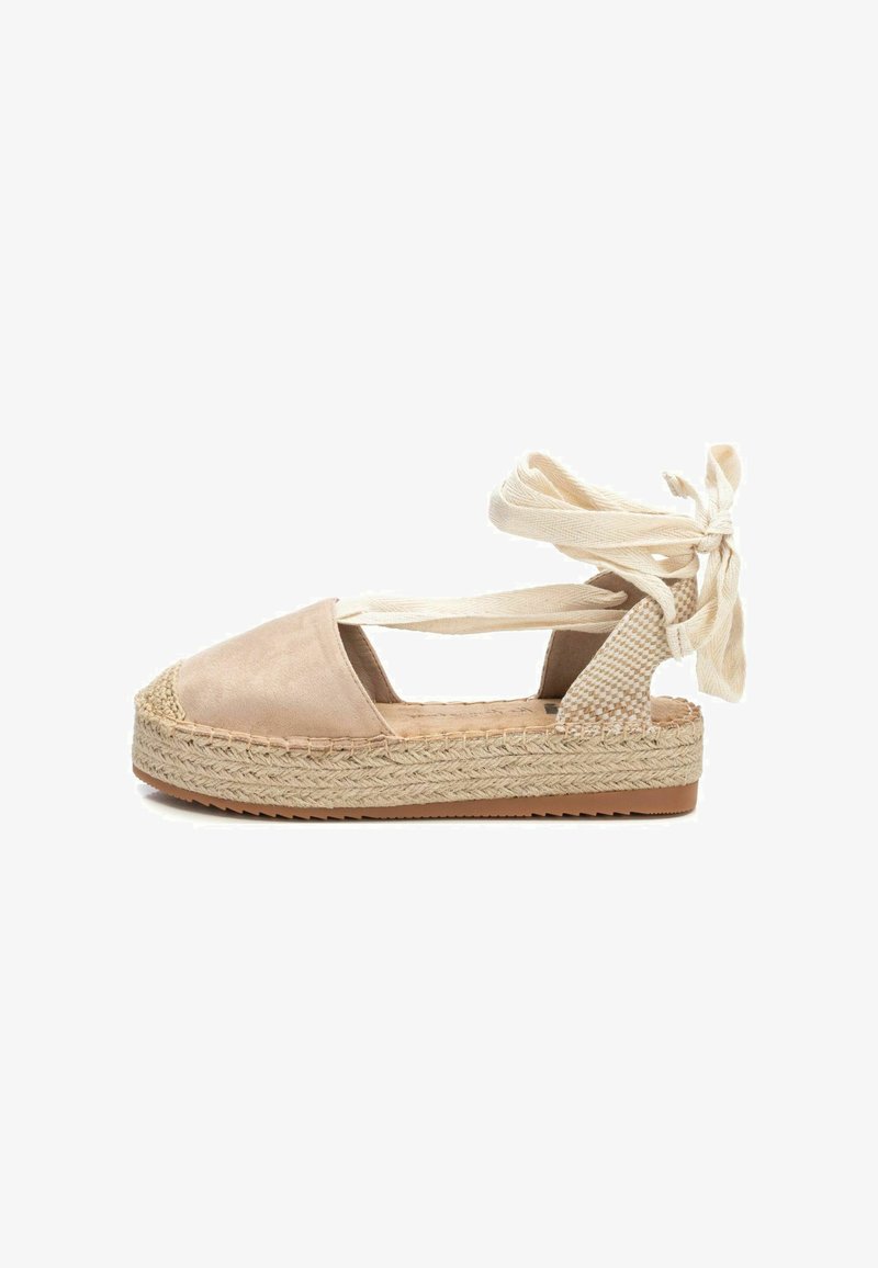 Espadrille beige con parte superior de ante, plataforma de yute trenzado y lazos en el tobillo. Presenta lados recortados y acentos texturizados en el talón.