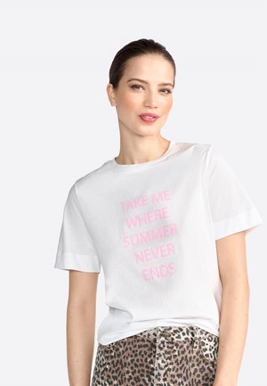 T-shirt en coton blanc à manches courtes et coupe décontractée, avec un texte rose : "EMMENEZ-MOI LÀ OÙ L'ÉTÉ NE FINIT JAMAIS." Pantalon à motifs imprimés animaliers.
