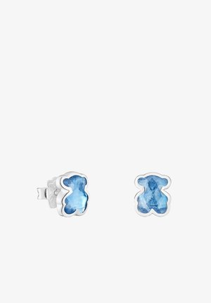 Des boucles d'oreilles en forme d'ours en peluche argenté présentent des pierres bleu clair translucides à texture facettée, conçues comme des clous d'oreille.