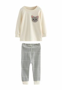 Cream long-sleeve top with a gray cat face patch; paired with navy and white checked leggings. Soft fabric, relaxed fit, ribbed cuffs.