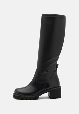 Black knee-high boots made of smooth leather with a chunky, textured block heel and side zip detailing.