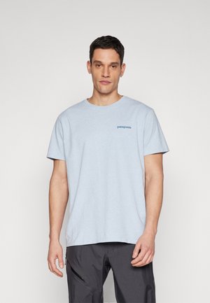 Camiseta de algodón de color azul claro con cuello redondo, que presenta un pequeño logo en azul oscuro de "patagonia" en el lado izquierdo del pecho. Mangas cortas y corte relajado.