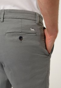 Grå bomullsshorts med smal passform, med en bakficka med knapp och en liten broderad design av en hund.