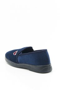Scarpa slip-on blu navy realizzata in tessuto a coste, con suola in gomma nera e un piccolo emblema rosso e bianco sul lato.