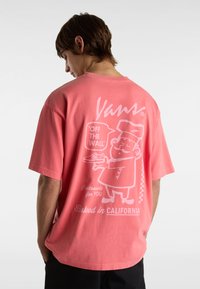 Korallenpinkes, übergroßes T-Shirt aus Baumwolle mit einer weißen Grafik eines Kochs, der einen Teller hält, und Text. Kurze Ärmel und abgerundeter Saum.