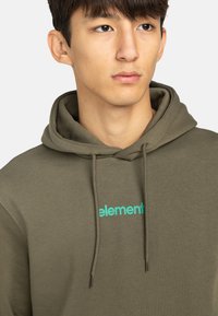 Felpa verde oliva con cappuccio regolabile, caratterizzata da un logo "element" turchese sul petto. Tessuto liscio e vestibilità comoda.