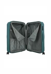 Valigia rigida turchese con un ampio interno in tessuto grigio, dotata di tasche a rete, elastici per fissare gli oggetti e quattro ruote per la mobilità.