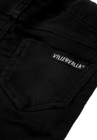 Schwarze Denim-Hose mit einer Gesäßtasche, die ein weißes "VILLERVALLA"-Label trägt. Der Stoff hat eine glatte Textur und ein klassisches Design.