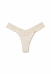 Beige tanga ondergoed met kanten rand, bloemenpatronen in de tailleband, een gladde stof en een V-vormig ontwerp aan de voorkant.