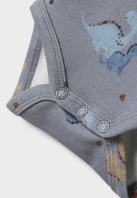 Gilet en coton gris avec un imprimé dinosaure en bleu et orange. Comprend une fermeture à pression en bas et une texture douce et lisse.