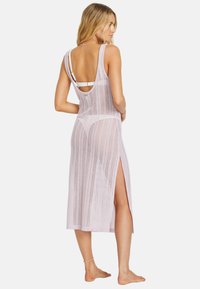 Lace-gehäkeltes, hell-lavendelfarbenes Überkleid mit seitlichen Schlitzen und offenem Rückendesign. Ärmellos mit lockerer Passform, die die Haut darunter zur Schau stellt.