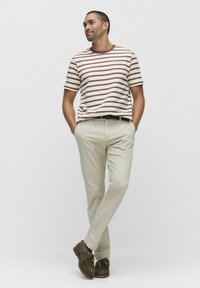 Randig t-shirt med kort ärm i beige och brunt, kombinerad med ljusbeige chinos och mörkbruna skor, med en avslappnad passform och skärp.