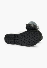 Footwear with a textured black rubber outsole and a light blue and white upper, featuring a smooth finish and minimal design.