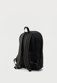 Μαύρο σακίδιο πλάτης με επενδυμένους ιμάντες, λεία υφή υφάσματος και κομψό σχήμα με ρυθμιζόμενες πλαϊνές αγκράφες.