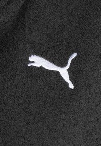 Tessuto di asciugamano nero con una texture morbida e un logo Puma ricamato in bianco che presenta un design stilizzato di un gatto che salta.