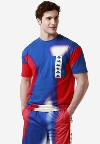 Camiseta de hombre de manga corta con un patrón de tie-dye en azul y rojo, con un bolsillo en el pecho y un logo de banda en el bolsillo, hecha de una mezcla de algodón.