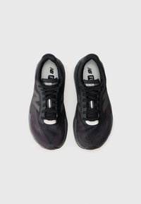 Baskets de course noires avec tige en mesh, fermeture à lacets et semelle rembourrée. Présente le logo et la marque "FuelCell rebel" sur la languette.
