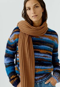 Gestreifter Strickpullover in Blau, Braun und Creme, kombiniert mit einem einfarbigen braunen gerippten Schal. Beides ist gemütlich und strukturiert, geeignet für kaltes Wetter.