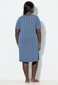 Modré šaty délky po kolena s krátkými rukávy, zdobené vzorovanou texturou a bočními rozparky pro lepší pohyb. Hladký textura látky.