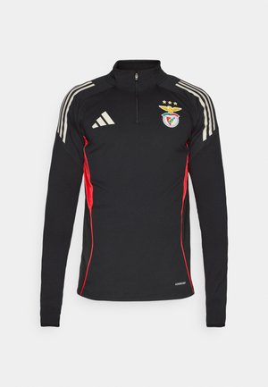 Black long-sleeve sports shirt with red side accents, half-zip collar, three white stripes on shoulders, and embroidered logo on chest.