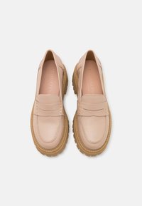 Fletse roze leren loafers met een ronde neus, decoratieve stiksels en een dikke rubberen buitenzool. Het interieur heeft een reliëfbranding.