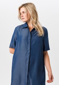 Denim jurk in donkerblauw met korte mouwen, een knoopsluiting aan de voorkant en een opgevouwen kraag met contrasterende stikseldetails.