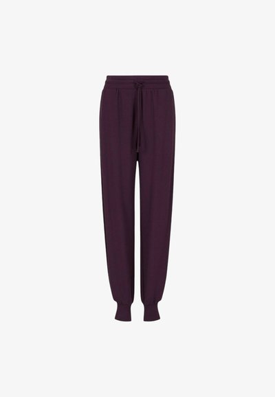 Pantaloni jogger di colore viola scuro realizzati in morbido tessuto, con vita elastica e cordino, e polsini a sbuffo alla caviglia.