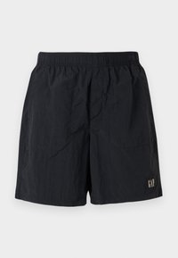 Sorte shorts med elastisk talje, med et logomærke nederst til højre, lavet af letvægtsstof med en krøllet tekstur.
