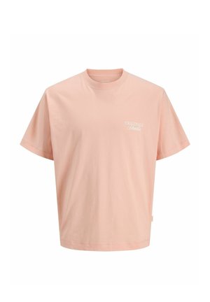 Jasnoróżowy T-shirt z krótkim rękawem i okrągłym dekoltem, z małym białym napisem "ORIGINALS Studio" po lewej stronie na piersi.