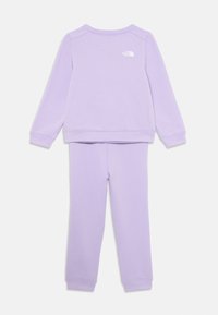 Fioletowy zestaw bluzy i spodni, wykonany z miękkiego materiału, z okrągłym dekoltem, ściągaczami na mankietach oraz białym logo z tyłu bluzy.