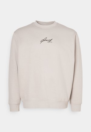 Beige Sweatshirt aus weichem Stoff mit Rundhalsausschnitt, langen Ärmeln und einem schwarzen gestickten Logo auf der Brust. Normale Passform.