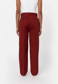 Röda vida byxor med hög midja, med två bakfickor och en mjuk bomullstextur. Platt front med sömdetaljer.