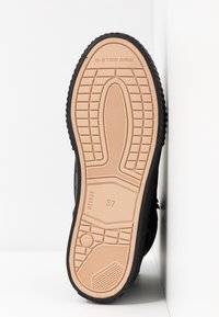 Semelle de chaussure avec bande de roulement beige, taille 37 indiquée, avec le branding G-Star Raw et des détails de grip à motifs, présentée sur fond blanc.
