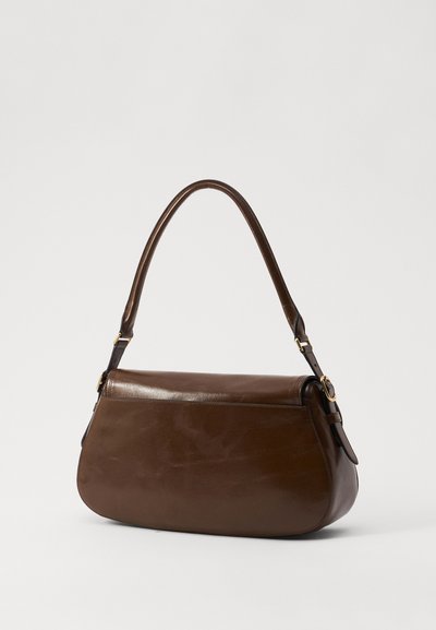 Brown leather handbag with a curved shape, single shoulder strap, and gold-tone hardware accents. Smooth texture and minimal design.