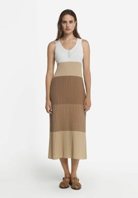 Stickad, ärmlös maxiklänning med v-ringning, med en färgblockdesign i vitt, beige och brunt, med ribbad textur.
