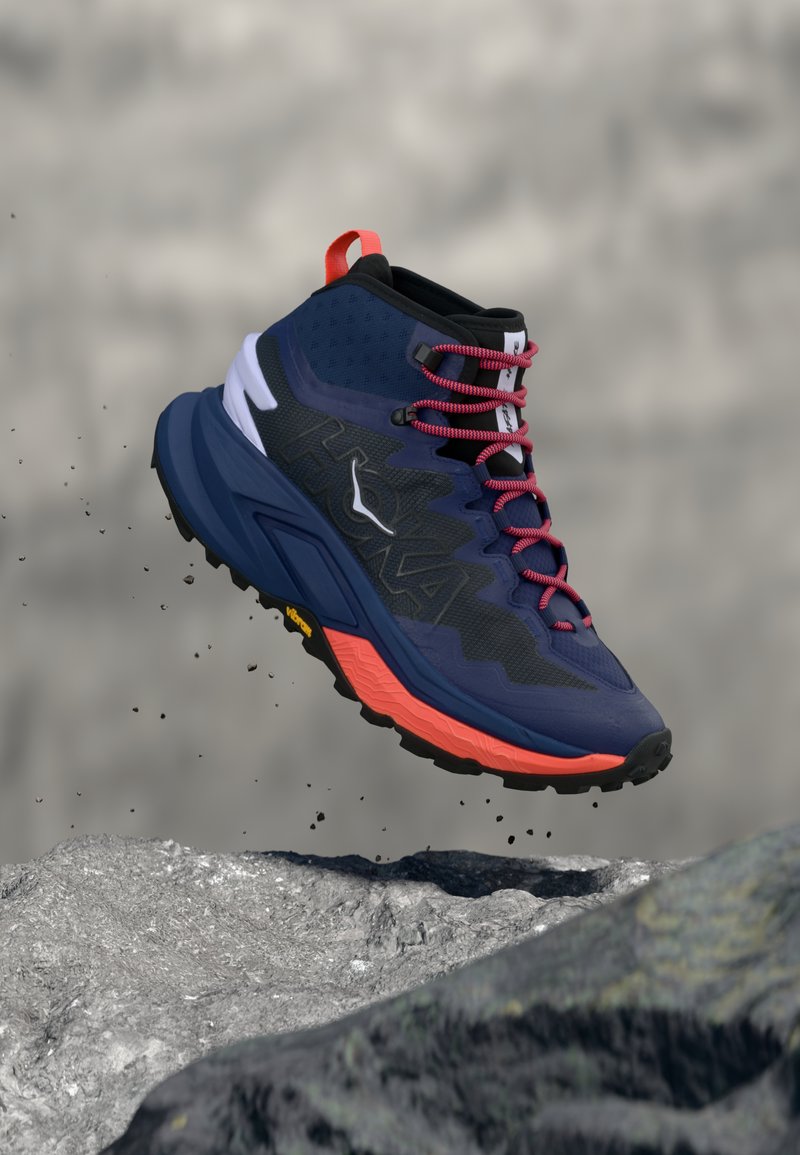 Αθλητικό παπούτσι υψηλού πάνω μέρους, μπλε ναυτικό με μαύρο δίχτυ, κόκκινα κορδόνια και πορτοκαλί σόλα. Διαθέτει ενδιάμεση σόλα με μαξιλάρι για απορρόφηση κραδασμών και ανθεκτική εξωτερική σόλα για πρόσφυση.