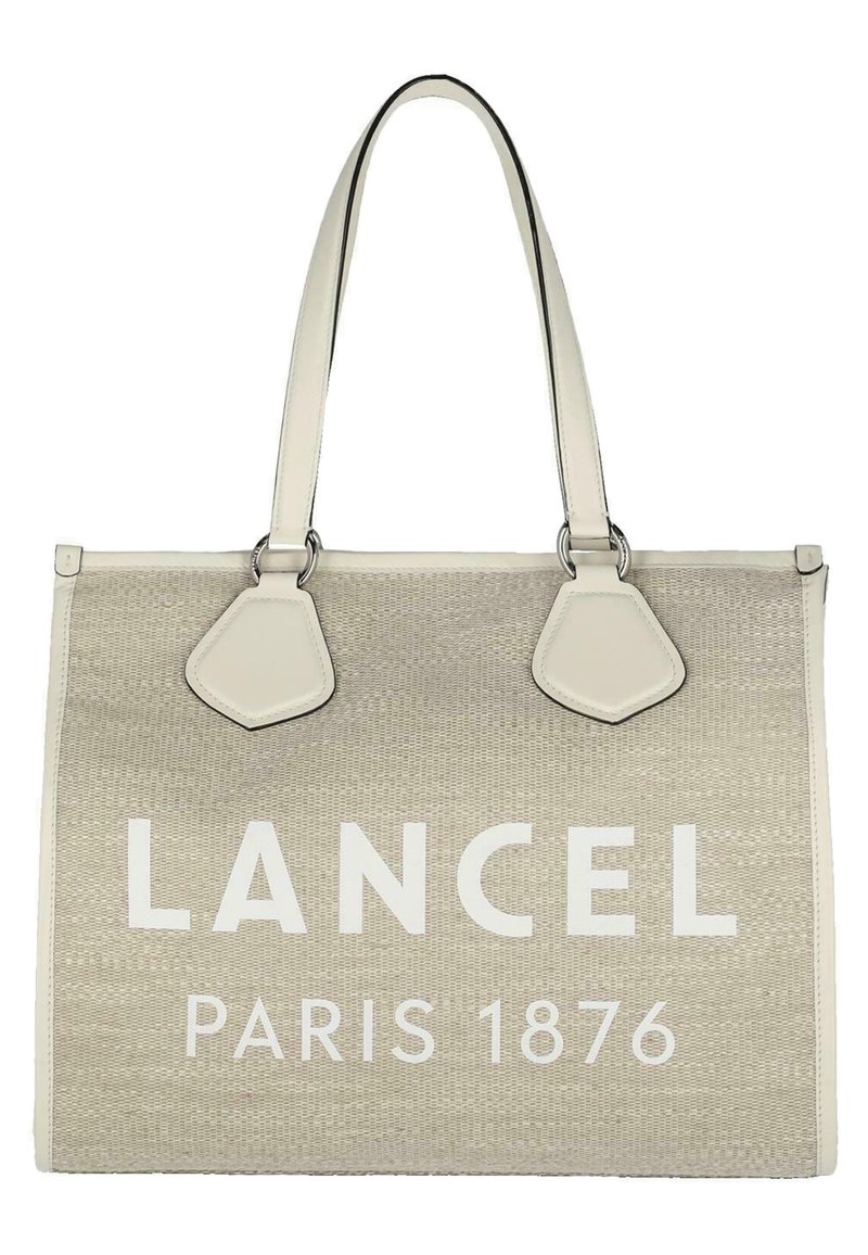 Sac beige avec le logo "LANCEL PARIS 1876" en blanc, fabriqué à partir de matériau tissé. Présente deux longues poignées et des accents en cuir sur les côtés.