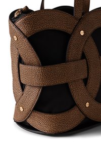 Sac en cuir brun texturé avec un corps en toile noire, présentant un design circulaire superposé et des accents en matériel doré.