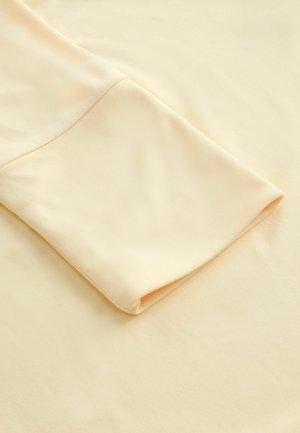 Jasno beżowa tkanina z złożonym rękawem, ukazująca gładką fakturę i miękki wygląd, podkreślająca swoją prostotę i elegancję.