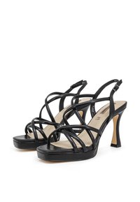 Sandali neri con cinturini a strappo e tacco alto, caratterizzati da cinturini sottili, un soletta imbottita e un design elegante con punta aperta e tacco affusolato.