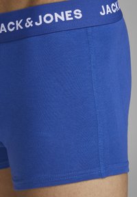Blaue Baumwoll-Boxershorts mit einem weißen elastischen Bund, der das Logo "JACK & JONES" zeigt, glatter Textur und körpernaher Passform.