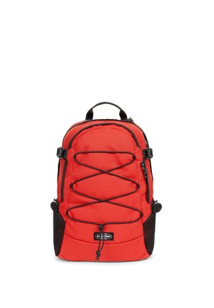 Mochila de nailon roja con bolsillos laterales de malla negra, correas ajustables y detalles de cordón elástico en el frente. Compartimentos con cremallera para almacenamiento.
